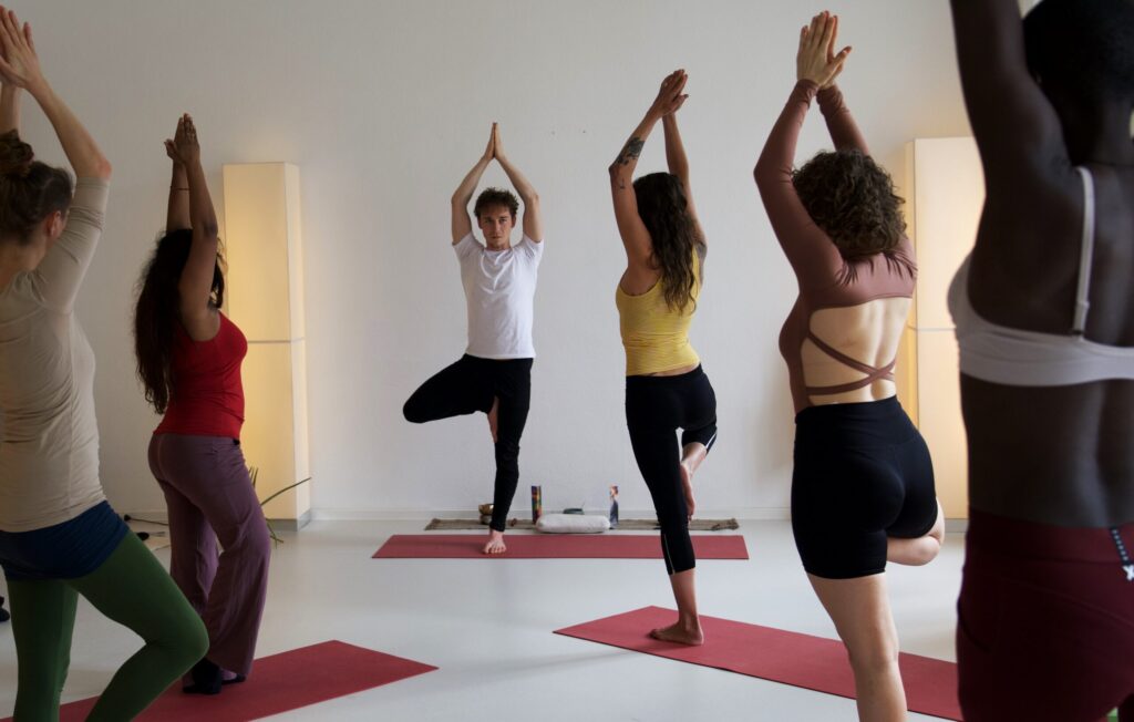 Leistungen Marek in der Baumhaltung (Vrikshasana) mit einer Gruppe